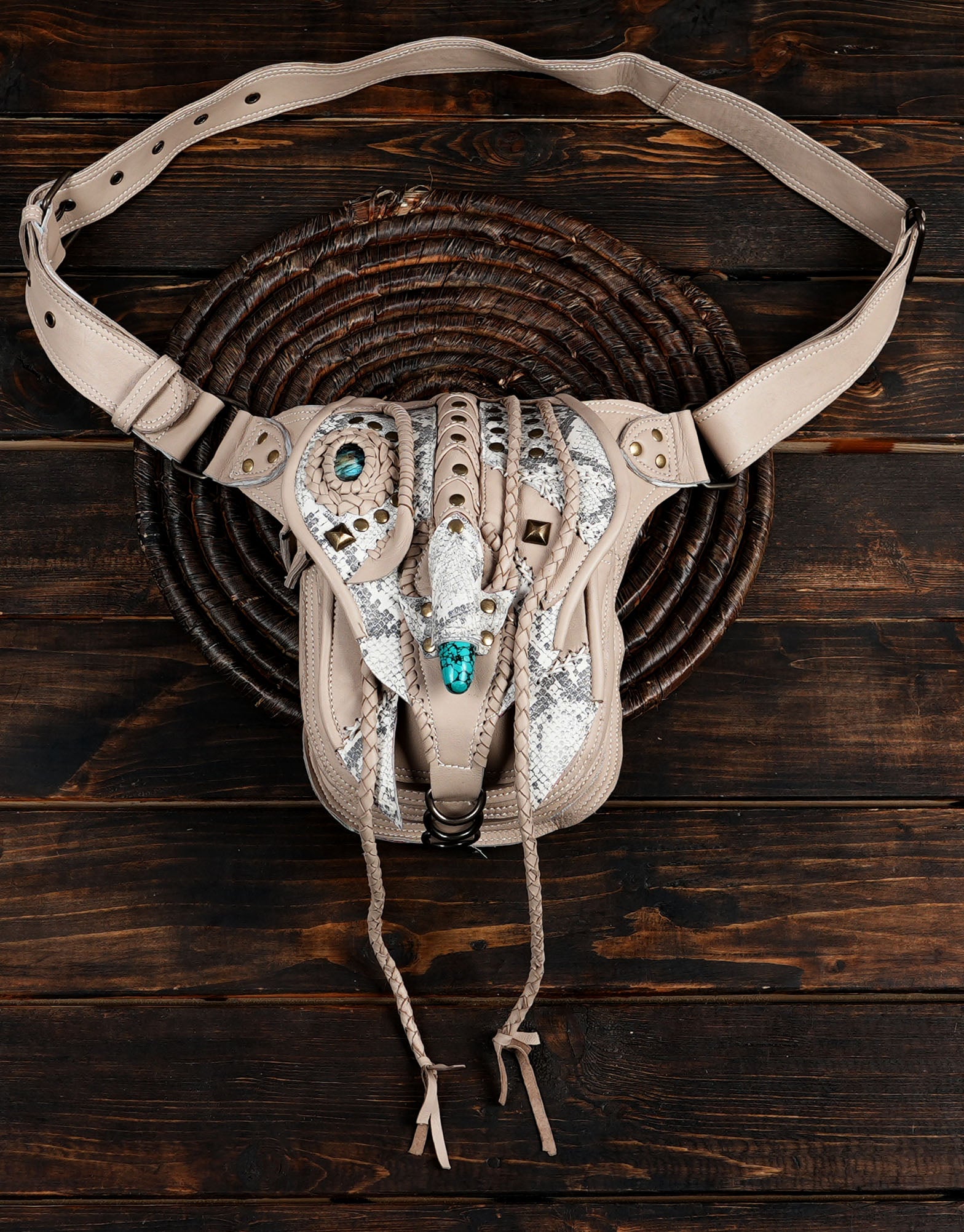 Artisan leather hip pouch with braided accents and gemstone centerpiece