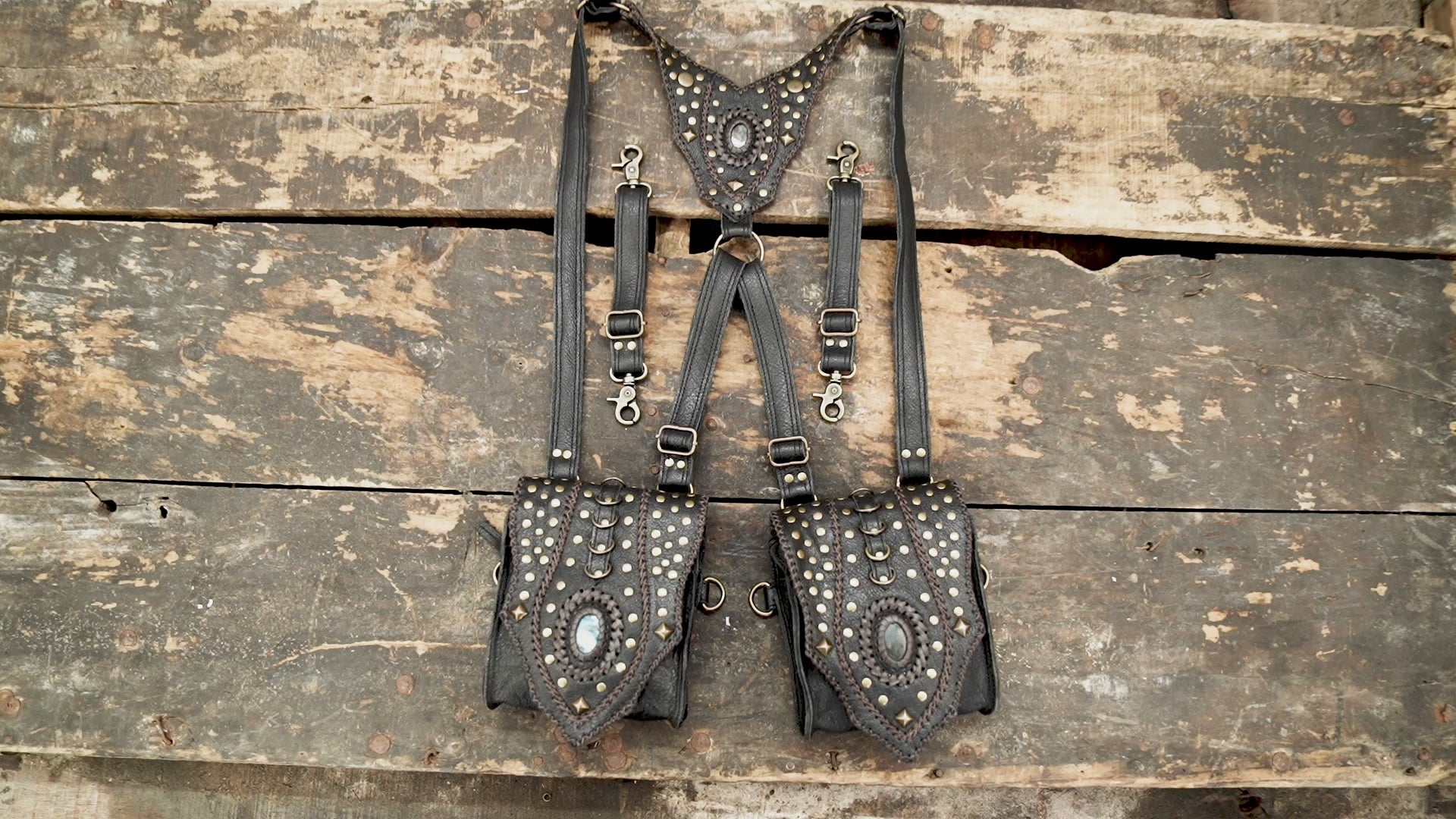 “Black leather festival holster with brass studs and decorative stone inlays”
