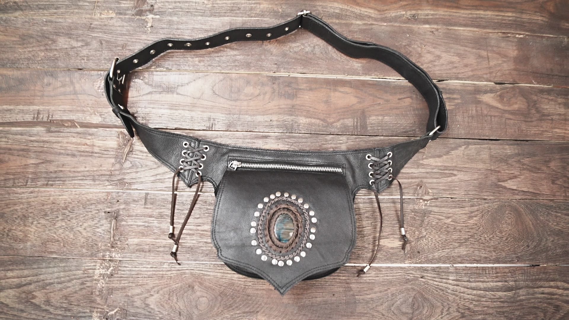 Artisan black leather hip pouch featuring gemstone detail and metallic studs.