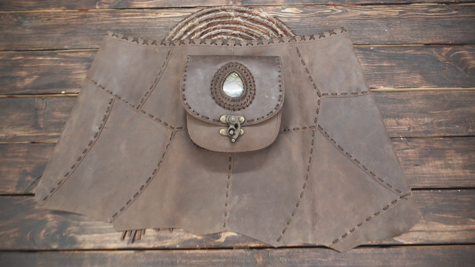 Crafted from soft brown leather with rustic stitching details.